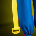 Jubilee coat hanging strap detail showing the yellow open buckle beside the blue trouser leg