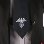 Close-up of the Enterprise dark tie showing the white eagle-and-shield emblem between the black coat lapels