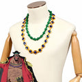 One Piece Blackbeard cosplay necklaces with green beads and blue accents in gold-colored settings beside character artwork