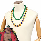 One Piece Blackbeard cosplay necklaces with green beads and blue accents in gold-colored settings beside character artwork