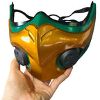 Front view of the Mizuki cosplay mask showing a raised gold-colored center, green border and two dark circular accents
