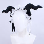 Front view of Fiona Gilman Crimson Priestess headpiece with curved black horns, white ruffles and dangling ribbons